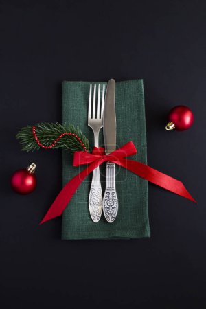 Téléchargez les photos : Table de Noël avec serviette verte sur fond noir. Vue du dessus. - en image libre de droit