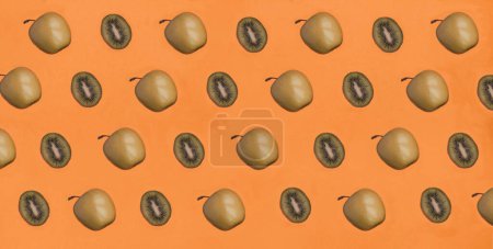 Photo for Green apple and kiwi on the orange background. Pattern. Flat lay. - Royalty Free Image