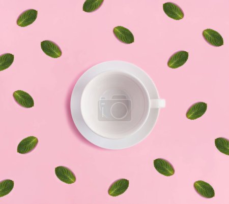Téléchargez les photos : Empty white cup for tea and mint on the pink background. Copy space. Top view. - en image libre de droit