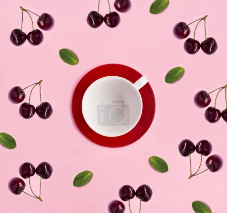 Foto de Taza blanca vacía para té, cerezas rojas y menta sobre el fondo rosa. Copiar espacio. Vista superior. - Imagen libre de derechos