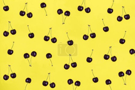 Photo for Red cherry on the yellow background. Top view. Falt lay. Pattern. - Royalty Free Image