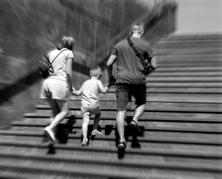 Téléchargez les photos : Flou de concentration, père et mère avec enfant montent les escaliers - en image libre de droit