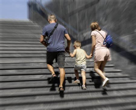 Téléchargez les photos : Flou de concentration, père et mère avec enfant montent les escaliers - en image libre de droit