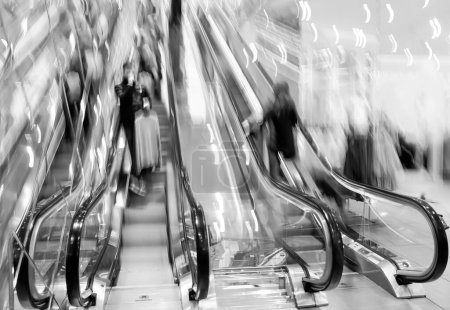 Téléchargez les photos : Image floue de personnes sur des escaliers roulants dans un centre commercial - en image libre de droit