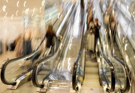 Téléchargez les photos : Image floue de personnes sur des escaliers roulants dans un centre commercial - en image libre de droit