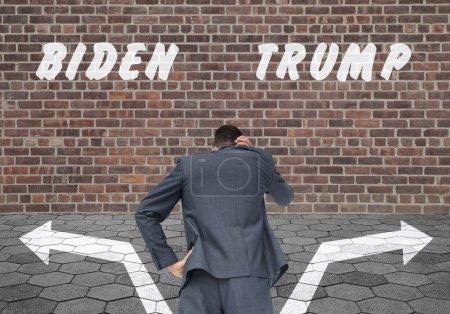 Foto de Hombre frente a un muro de ladrillo con inscripciones de Biden y Trump - Imagen libre de derechos