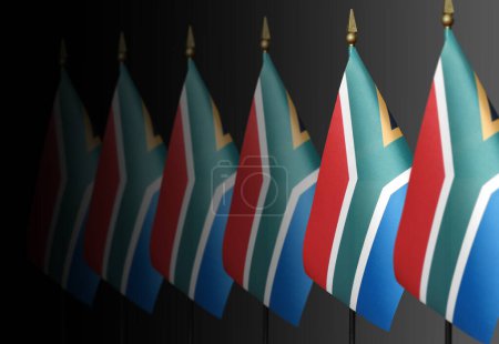 Row of South African flags on a dark background in perspective