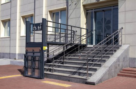 Der Eingang zum Gebäude ist mit Treppen und einem Aufzug für Menschen mit Behinderungen ausgestattet.