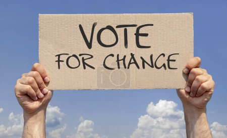 Hands holding a sign with the inscription: vote for change against the sky