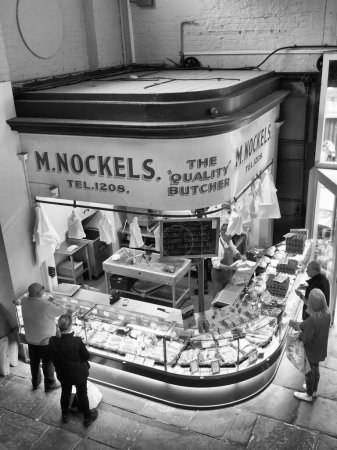 Photo for Scarborough, North Yorkshire, United Kingdom - 10 September 2022: M. Nockels traditional butchers shop in scarborough indoor market with a butcher selling meat to customers - Royalty Free Image