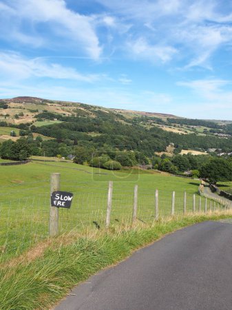 Photo for Narrow country lane in the calder valley near hebden bridge with home made road sign reading slow ere surrounded by calderdale west yorkshire scenery - Royalty Free Image