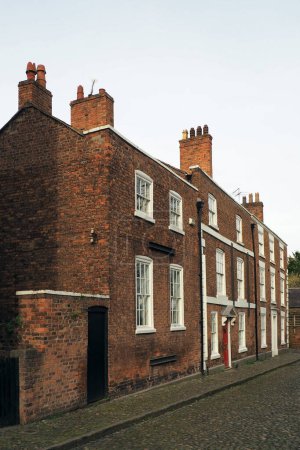 Photo for Street of old traditional red brick Georgian houses on a cobbled road in Chester England - Royalty Free Image