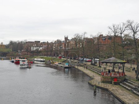 Photo for Chester. Cheshire, United Kingdom - 20 March 2024 : View of the river Dee in Chester with trip boats moored on the riverbank and old bandstand - Royalty Free Image