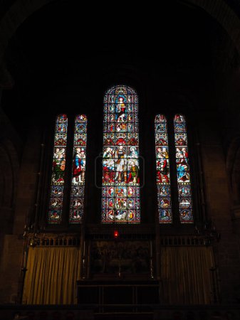 Chester. Cheshire, United Kingdom - 20 March 2024 : Stained glass west window showing scenes from the history of the church in St John the Baptist's Church, Chester. Created by Edward Frampton 1890