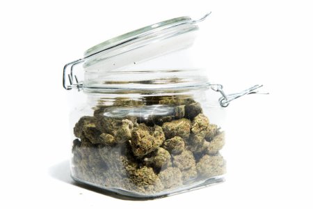 Téléchargez les photos : Pot en verre avec marijuana séchée isolé sur fond blanc - en image libre de droit