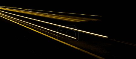gold lines of car lights on black background-stock-photo