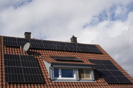 Foto de Módulos solares en el techo de un edificio residencial bajo el sol - Imagen libre de derechos