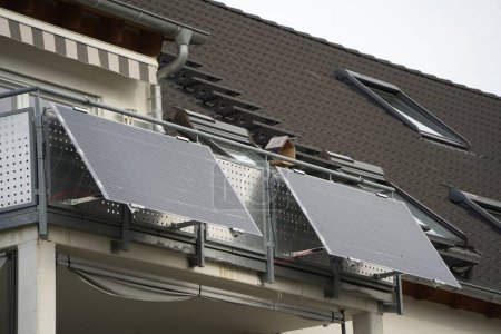 Solar panels on a balcony. The modules are placed at an angle to receive as much sunlight as possible. Electricity is produced even when the sky is gray.