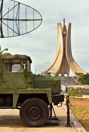 Foto de Argel, Argelia - 30 de abril de 2023: Vehículo histórico del ejército con antena y en el fondo del Memorial de los Mártires, Maqam Echahid. - Imagen libre de derechos