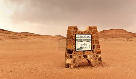Téléchargez les photos : Djanet, Algérie - 2 mai 2023 : Entrée au parc national de Tadrart avec une plaque, avec le désert désolé du Sahara en arrière-plan - en image libre de droit
