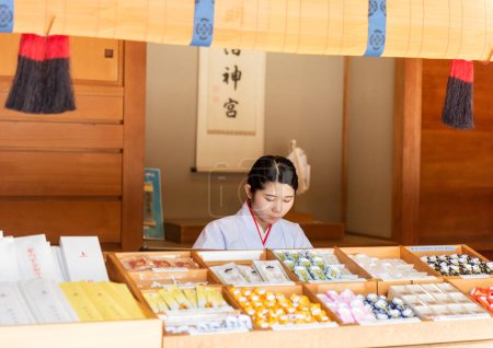 Téléchargez les photos : Une femme vendant des bibelots religieux au sanctuaire Meiji, un monument religieux shintoïste et une attraction touristique. - en image libre de droit
