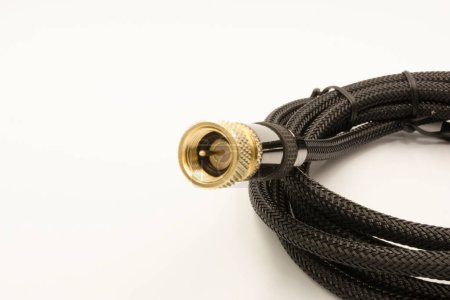 Photo for High quality black coaxial cable with a sleek, professional appearance with a woven texture ending in a detailed gold connector with grooves on the gold part for easy attachment. - Royalty Free Image