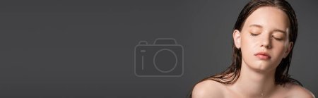 Photo for Young model with wet face and naked shoulders closing eyes isolated on grey, banner - Royalty Free Image