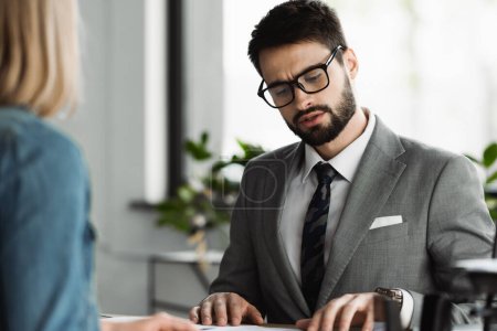 Photo for Businessman in eyeglasses talking to blurred job seeker in office - Royalty Free Image