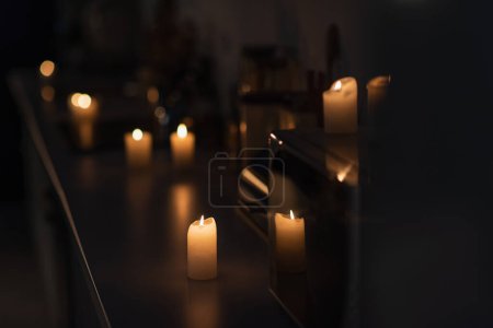 Téléchargez les photos : Cuisine sombre avec des bougies brûlant sur le plan de travail pendant la panne d'énergie - en image libre de droit
