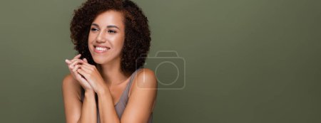 Pretty african american woman in top looking away isolated on green, banner 