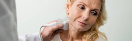 Arzt macht Nackenuntersuchung der blonden reifen Frau mit Ultraschall, Banner