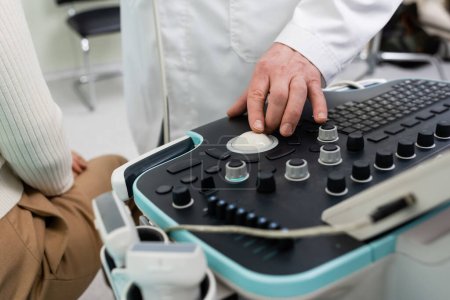 Foto de Vista parcial del médico ajustando la máquina de ultrasonido antes del diagnóstico del paciente - Imagen libre de derechos