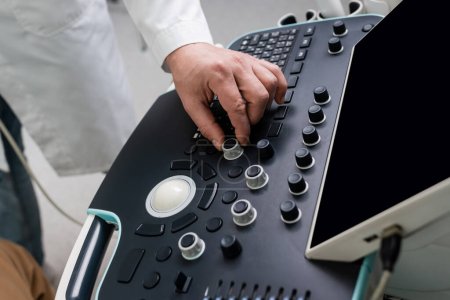 Foto de Vista parcial del médico que trabaja con la máquina de ultrasonido moderna en la clínica - Imagen libre de derechos