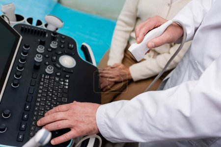 Photo for Partial view of doctor using console of ultrasound machine near woman in clinic - Royalty Free Image