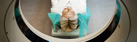 Hochwinkelaufnahme einer Frau mit geschlossenen Augen bei der Diagnostik auf dem CT-Scanner, Banner