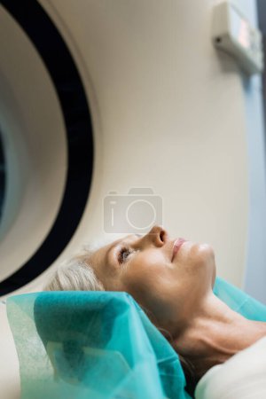 pretty middle aged woman doing scanning on computed tomography machine