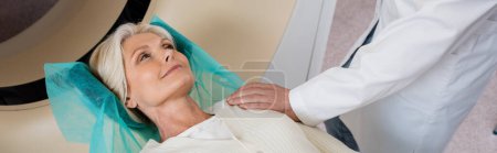 Photo for Radiologist touching shoulder of positive middle aged woman before computed tomography in clinic, banner - Royalty Free Image