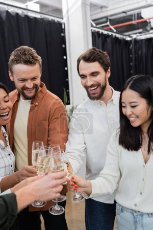 Téléchargez les photos : Gai interracial hommes d'affaires clinquant champagne pendant la fête d'entreprise - en image libre de droit