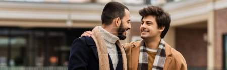 Photo for Happy gay couple in stylish outfits looking at each other outdoors, banner - Royalty Free Image