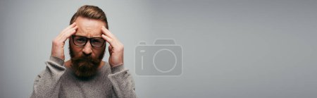 Téléchargez les photos : Homme tendu à lunettes regardant la caméra isolée sur gris, bannière - en image libre de droit