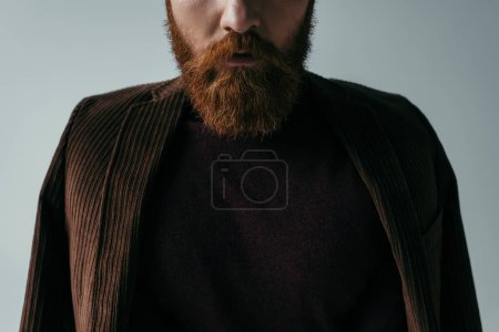 cropped view of bearded man in turtleneck and blazer isolated on grey 
