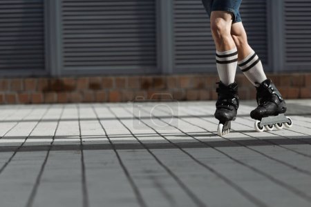 Foto de Vista recortada del hombre en pantalones cortos y patines patinaje al aire libre - Imagen libre de derechos