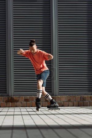 Téléchargez les photos : Homme en vêtements décontractés et patins à roulettes dans la rue urbaine - en image libre de droit