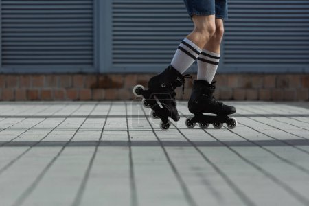 Téléchargez les photos : Vue recadrée de l'homme en chaussettes de genou et patins à roulettes à l'extérieur - en image libre de droit