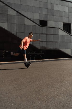 Photo for Side view of young roller skater riding on one leg on city street - Royalty Free Image