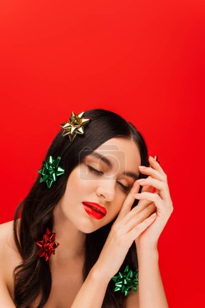 Photo for Woman with visage and gift bows on hair posing isolated on red - Royalty Free Image
