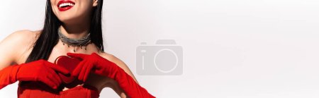 Téléchargez les photos : Vue recadrée du modèle avec lèvres rouges et gants tenant cadeau en forme de coeur isolé sur blanc, bannière - en image libre de droit