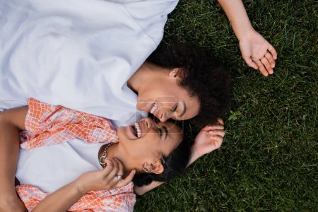 vue de dessus des femmes lesbiennes africaines américaines gaies allongées sur l'herbe 