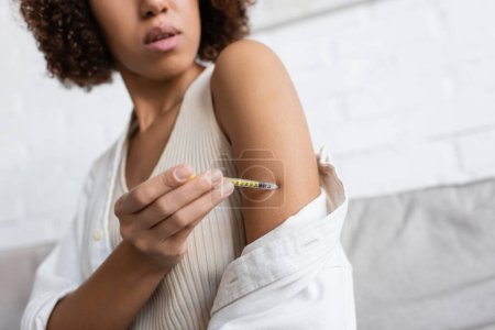 Ausgeschnittene Ansicht einer afrikanisch-amerikanischen Frau mit Diabetes beim Insulinspritzen im Arm zu Hause 