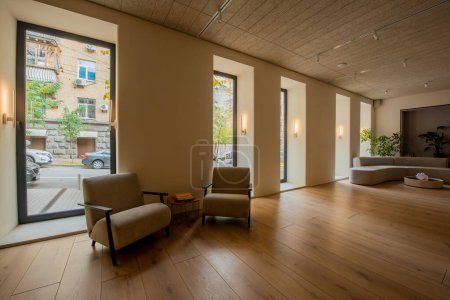 Téléchargez les photos : Modern armchairs near round coffee table in spacious lobby of hotel - en image libre de droit
